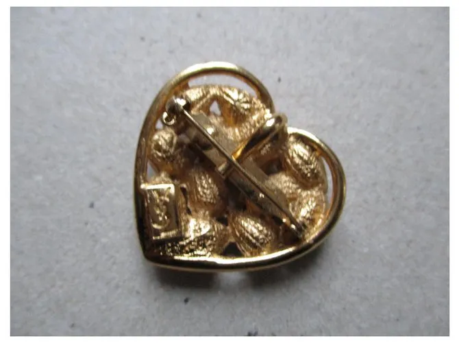 Yves Saint Laurent Broche de corazón dorado, piedras rosadas. 